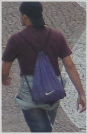 Detalhe tamanho natural de foto com zoom, rapaz caminhando na calçada