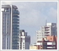 Recorte tamanho natural, topos de edifícios, céu azul, ângulo largo, a 500 m da Sony DSC-H90